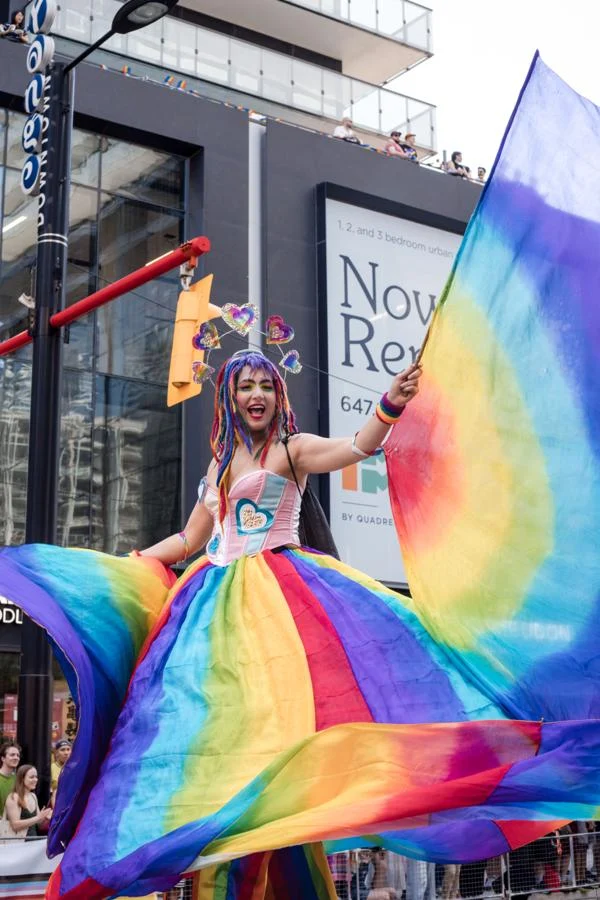 Performer holding flowing rainbow fabric